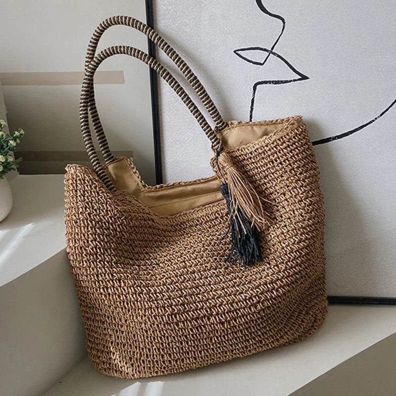 Borsa da spiaggia estiva in paglia intrecciata con nappe
