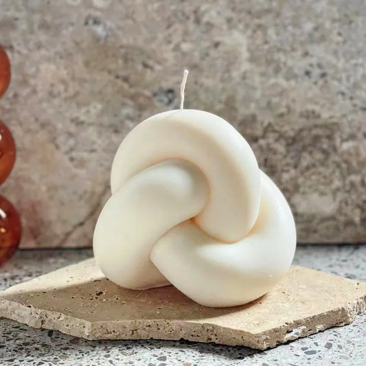 Candele con nodi lavorati a maglia e palline di corda intrecciata